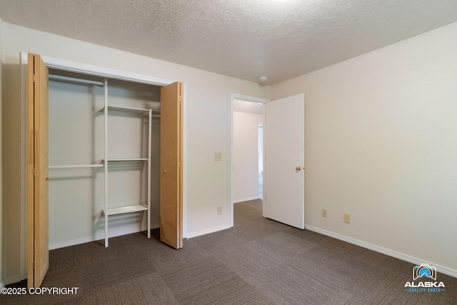 4477 Panther Dr, Eagle River, AK 99577 - unfurnished bedroom featuring dark colored carpet, a closet, baseboards, and a textured ceiling
