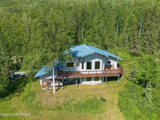 4477 Panther Dr, Eagle River, AK 99577 - back of house featuring a wooded view, a wooden deck, metal roof, and a lawn