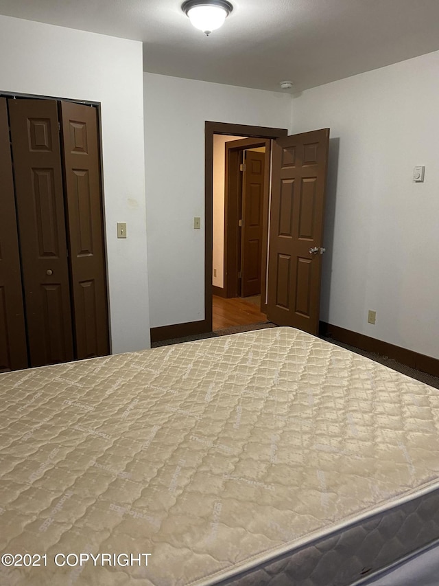 unfurnished bedroom featuring a closet and baseboards