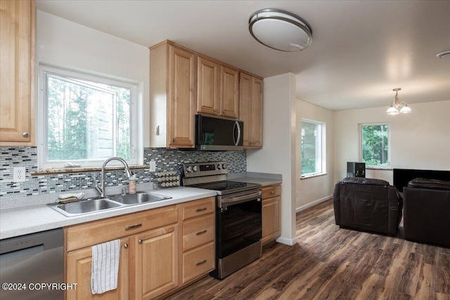 kitchen with sink, decorative light fixtures, appliances with stainless steel finishes, dark hardwood / wood-style floors, and decorative backsplash