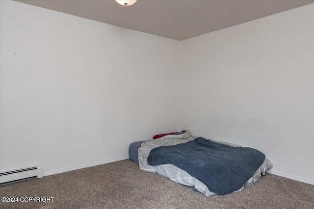 bedroom with a baseboard heating unit and carpet