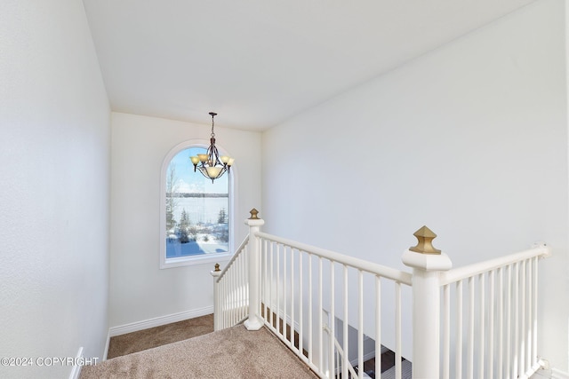 stairway featuring carpet and a chandelier