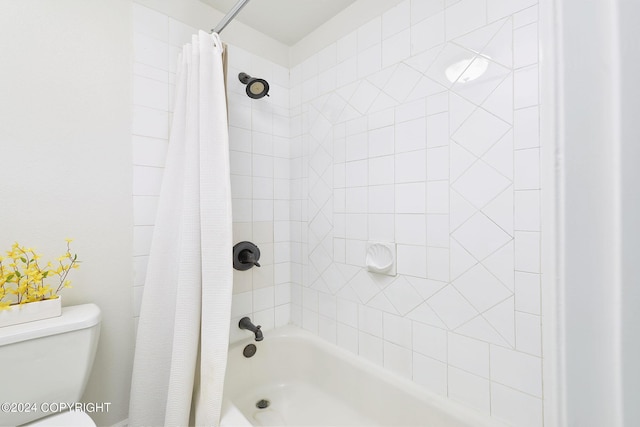 bathroom featuring shower / bath combo and toilet