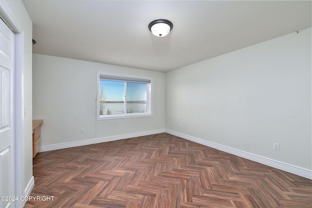 spare room featuring dark parquet floors