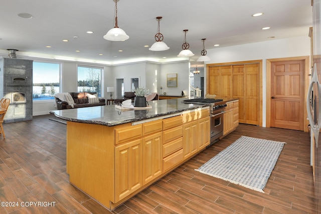 kitchen with pendant lighting, dark stone counters, a center island, high end stainless steel range, and light brown cabinets