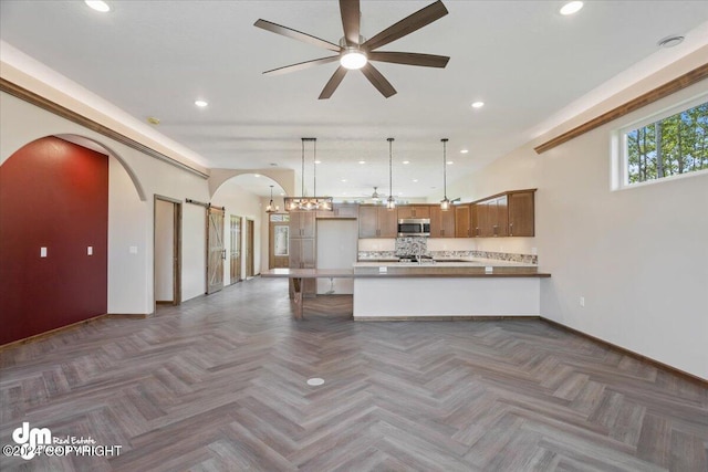 kitchen featuring pendant lighting, dark parquet flooring, ceiling fan, tasteful backsplash, and kitchen peninsula