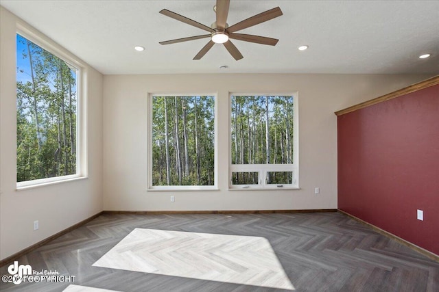 empty room featuring ceiling fan and dark parquet flooring