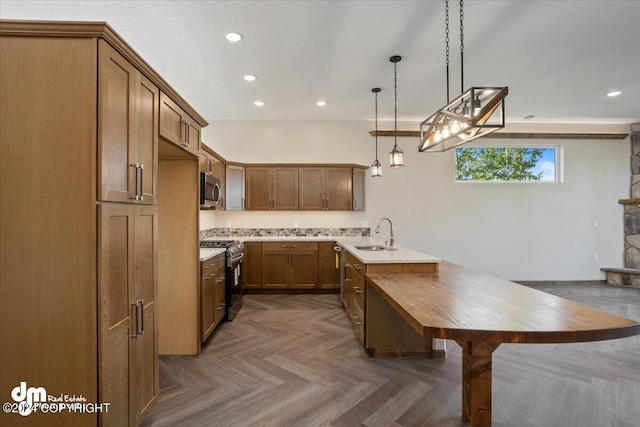 kitchen featuring kitchen peninsula, dark parquet floors, pendant lighting, stainless steel appliances, and sink