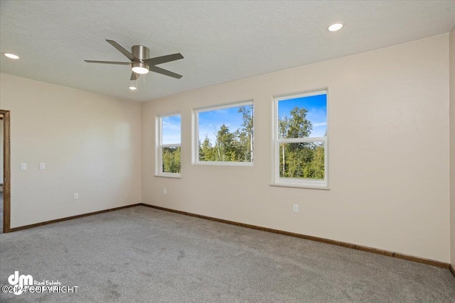 carpeted empty room featuring ceiling fan and a textured ceiling