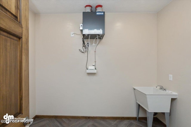 laundry room featuring water heater and parquet floors