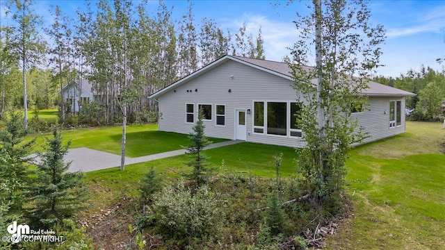 rear view of property featuring a lawn