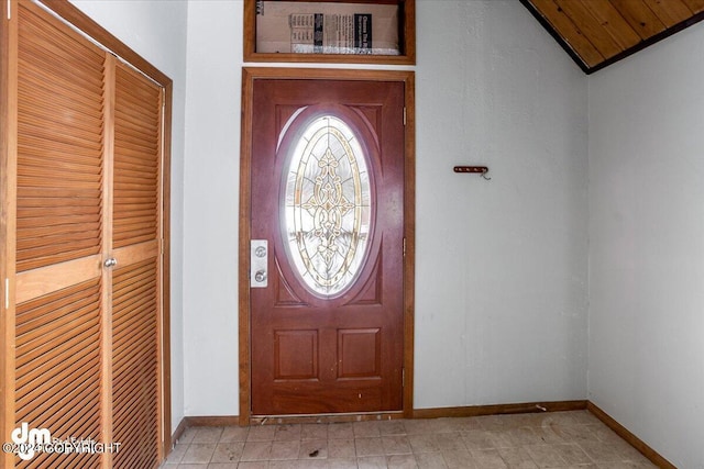 foyer entrance featuring lofted ceiling and baseboards