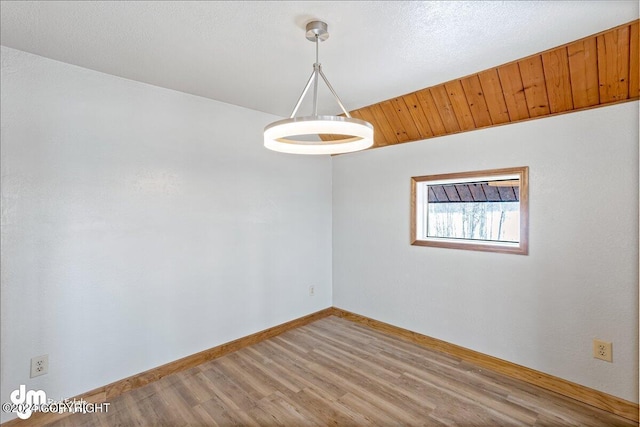 unfurnished room with baseboards and wood finished floors