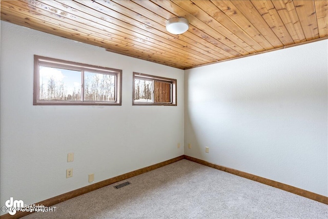 carpeted empty room featuring wooden ceiling, visible vents, and baseboards