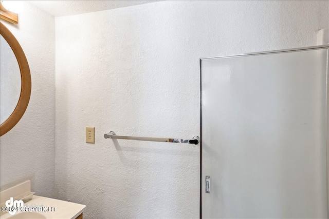 bathroom featuring a textured wall and vanity