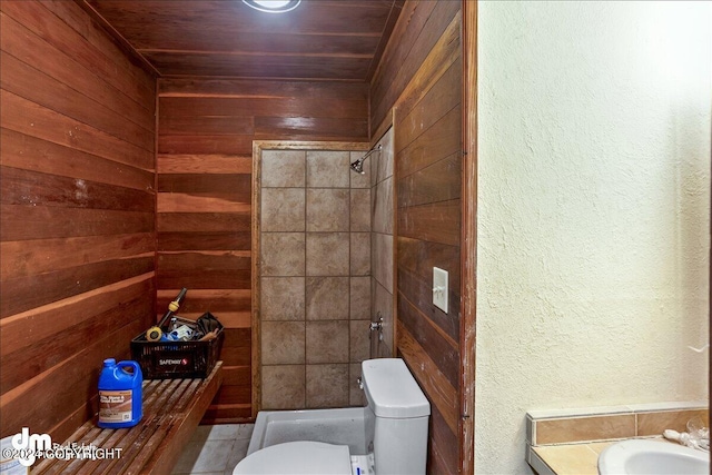 full bath featuring toilet, wooden walls, a sink, wood ceiling, and tiled shower