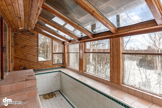 unfurnished sunroom featuring lofted ceiling and a jacuzzi