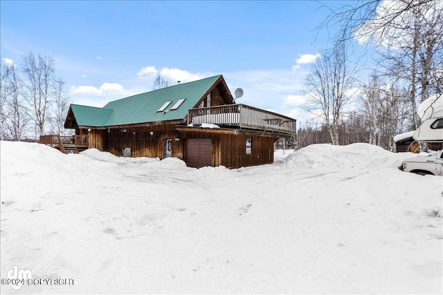 view of snowy exterior featuring a wooden deck and a garage