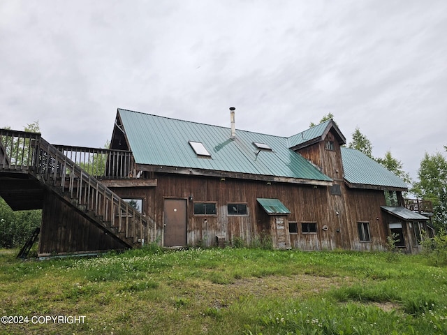 rear view of house featuring metal roof and stairway