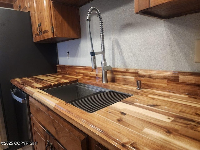 details featuring wooden counters, a hot tub, brown cabinetry, a sink, and dishwasher