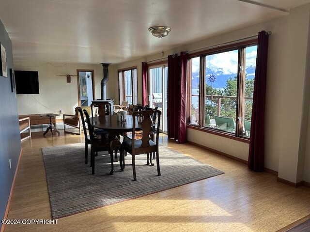 dining room featuring wood-type flooring and a wood stove