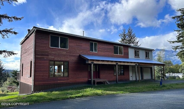 view of front of home with a mountain view and a front lawn