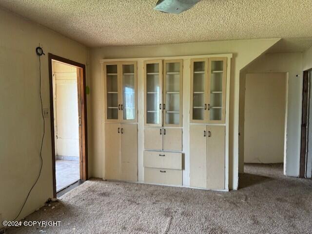 carpeted spare room featuring a textured ceiling