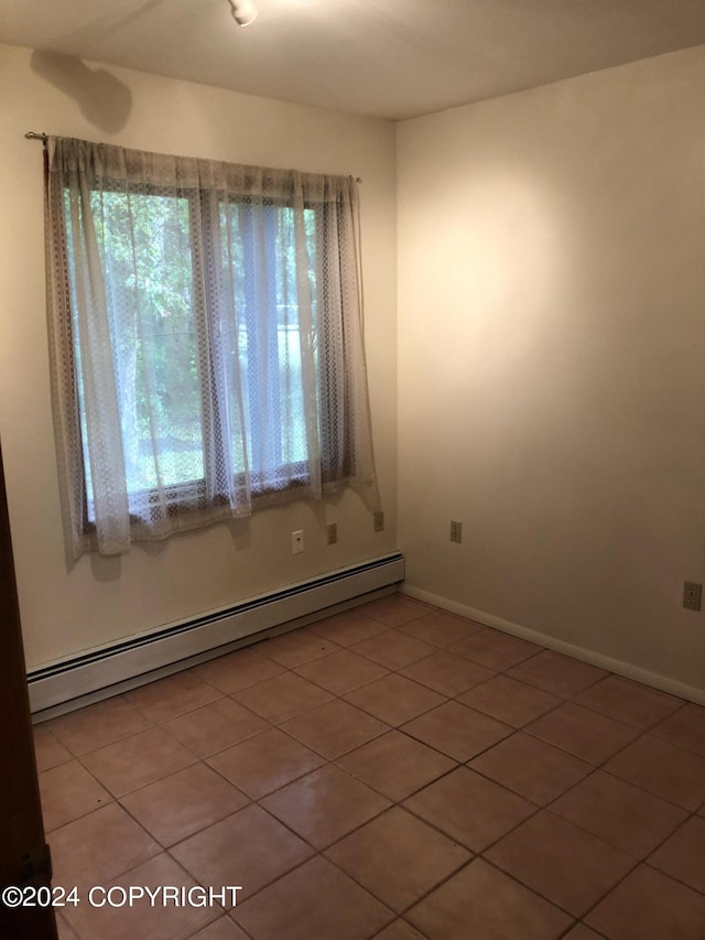 unfurnished room with a baseboard heating unit