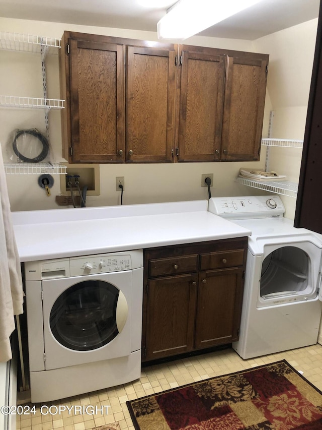 laundry room featuring washing machine and dryer and cabinets