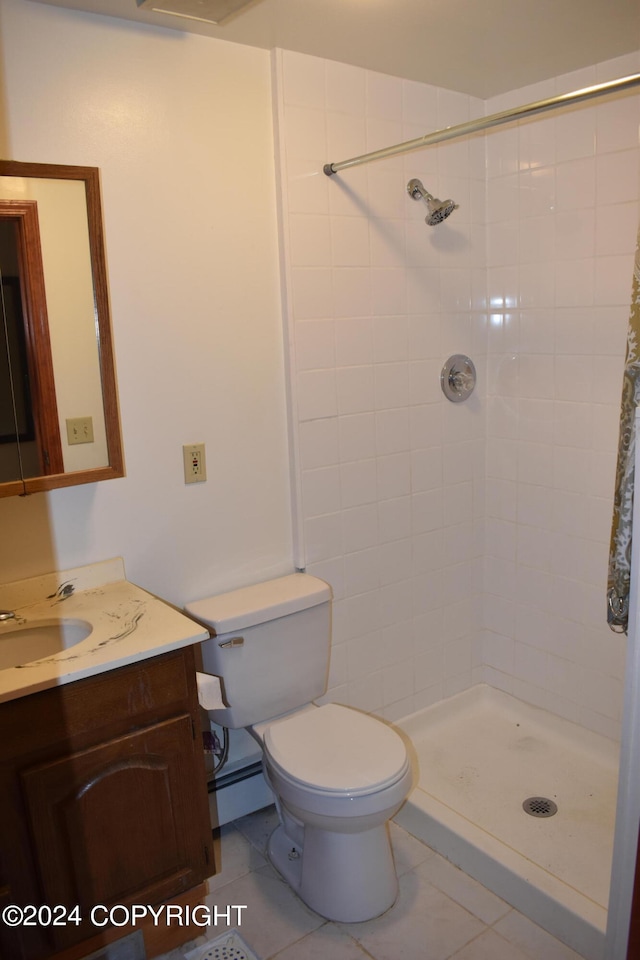 bathroom featuring baseboard heating, tile patterned flooring, vanity, a tile shower, and toilet