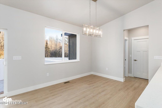 unfurnished dining area featuring light hardwood / wood-style flooring and lofted ceiling