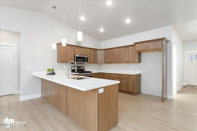 kitchen with stainless steel appliances, sink, light hardwood / wood-style flooring, pendant lighting, and vaulted ceiling