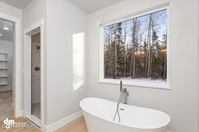 bathroom featuring hardwood / wood-style floors, a healthy amount of sunlight, and separate shower and tub