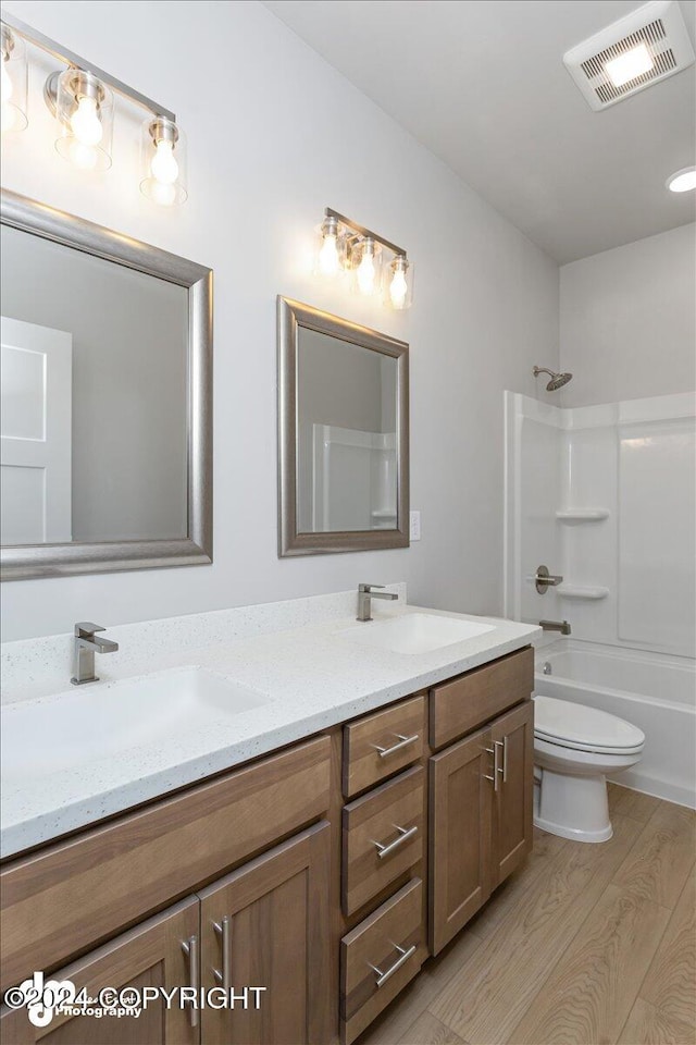 full bathroom featuring shower / bath combination, hardwood / wood-style flooring, toilet, and vanity