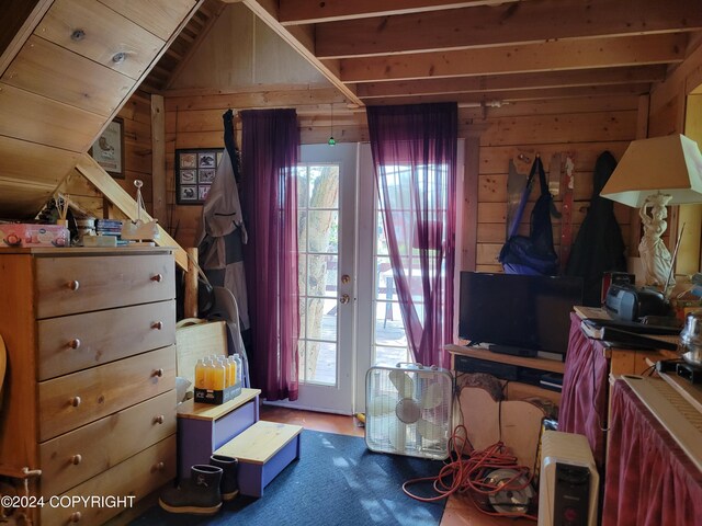 bedroom with lofted ceiling and wooden walls