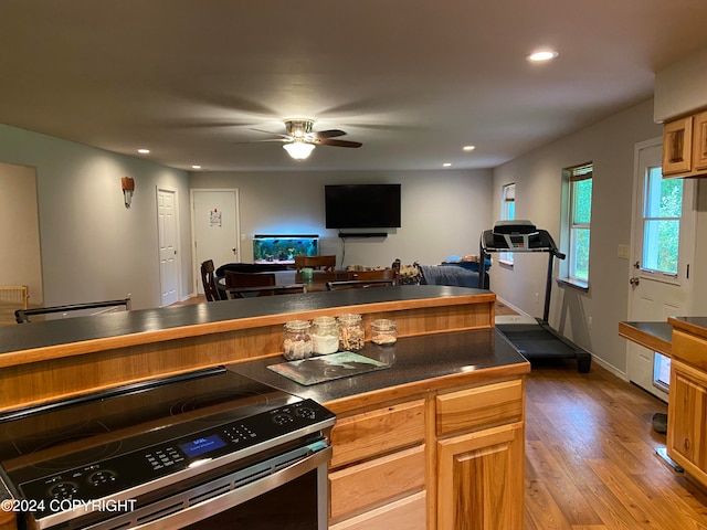 kitchen with stainless steel range with electric cooktop, wood-type flooring, and ceiling fan