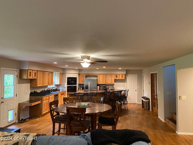 dining space with ceiling fan, sink, and light hardwood / wood-style floors