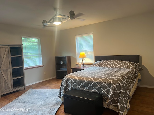 bedroom with multiple windows, ceiling fan, and hardwood / wood-style floors