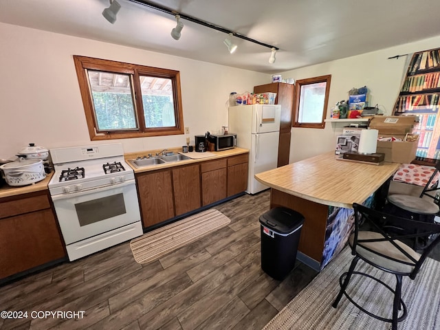 kitchen with white appliances, dark hardwood / wood-style flooring, a breakfast bar, and sink