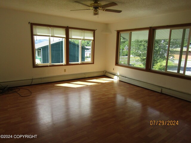 unfurnished room featuring hardwood / wood-style flooring, a textured ceiling, ceiling fan, and a healthy amount of sunlight