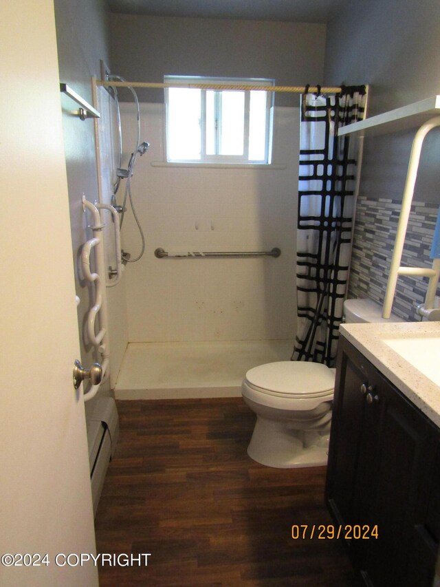 bathroom with baseboard heating, hardwood / wood-style floors, toilet, vanity, and a shower with curtain