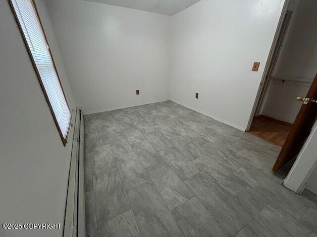 unfurnished bedroom featuring baseboard heating