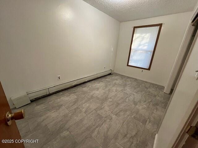 unfurnished bedroom featuring a textured ceiling and a baseboard radiator