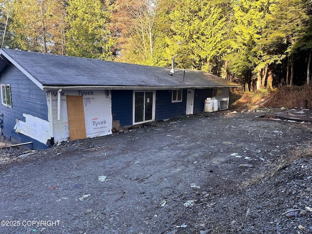 back of property featuring a shingled roof