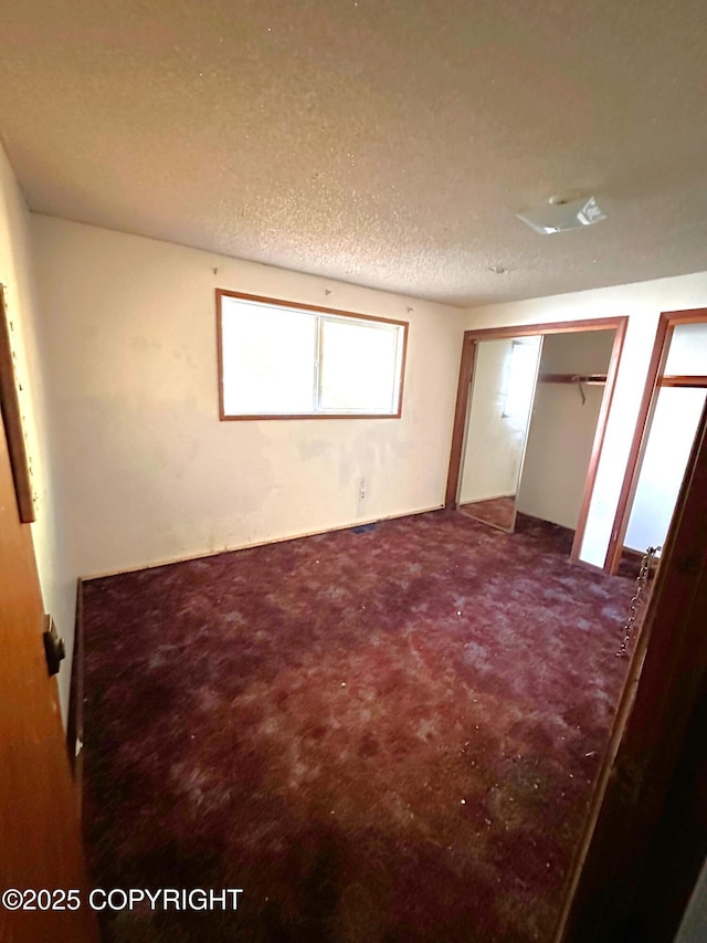 unfurnished bedroom with carpet floors and a textured ceiling