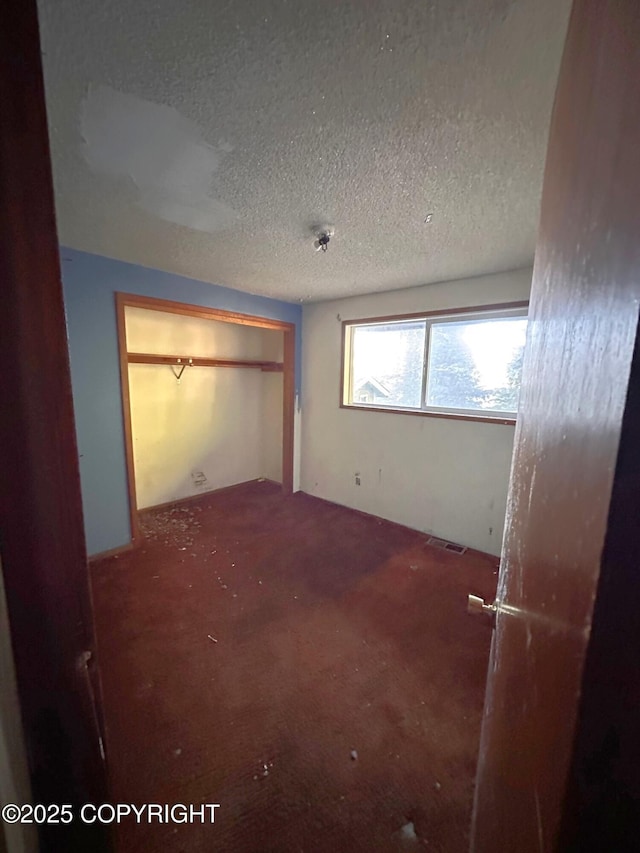 unfurnished bedroom featuring visible vents and a textured ceiling