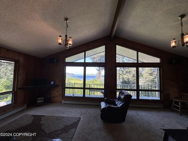 unfurnished living room featuring an inviting chandelier, a baseboard radiator, wooden walls, and carpet flooring