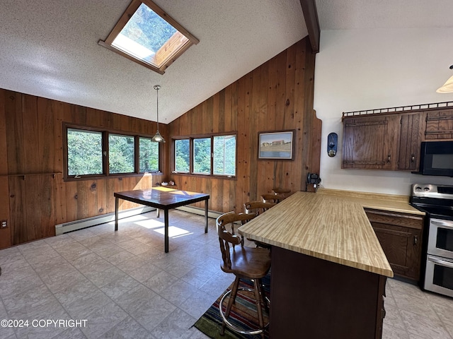 kitchen featuring stainless steel electric range, light tile patterned flooring, wood walls, a textured ceiling, and vaulted ceiling with skylight