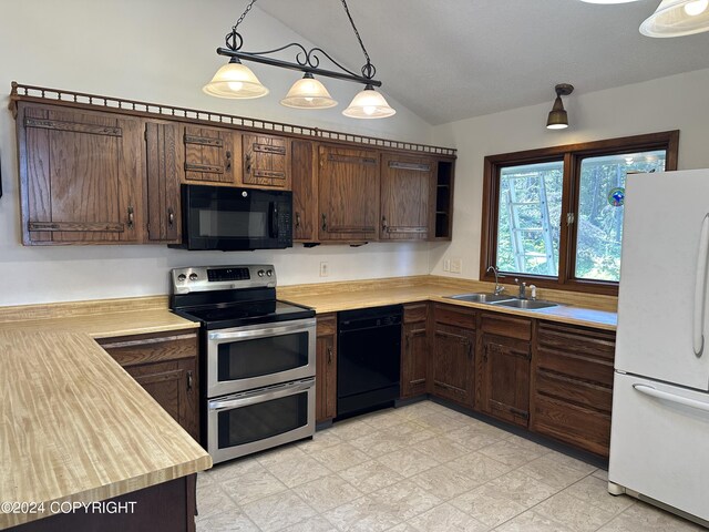 kitchen featuring light tile patterned flooring, black appliances, decorative light fixtures, dark brown cabinetry, and sink