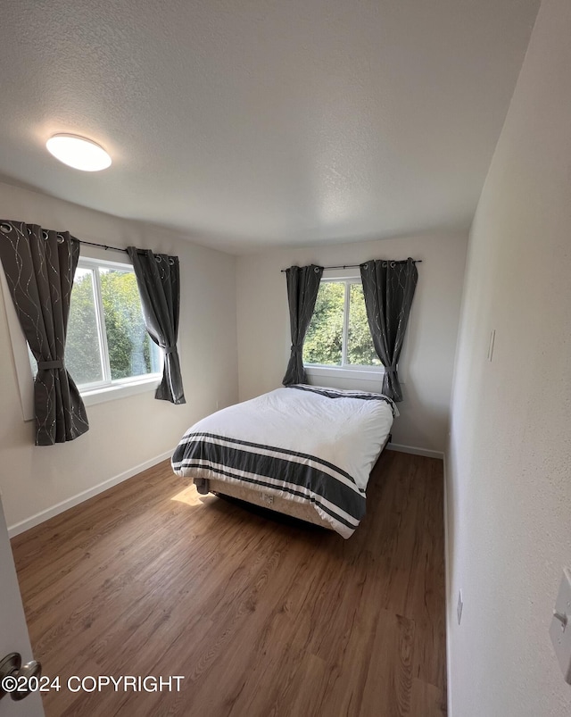 bedroom featuring hardwood / wood-style floors and a textured ceiling